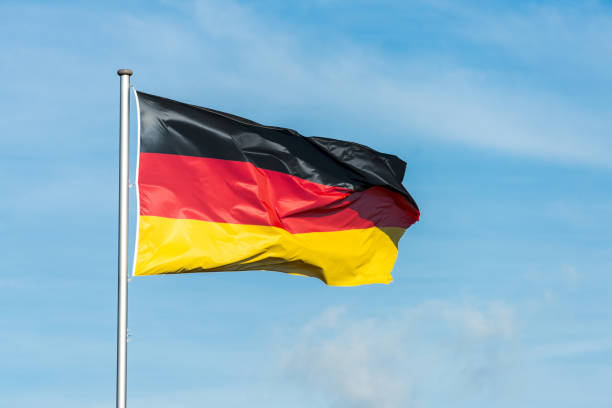 istock German flag waggling in the wind with sky in background 910942860
