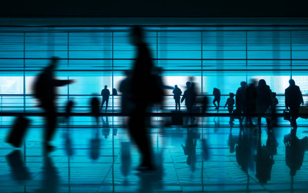 空港の通路で反射を歩く人々 - arrival departure board airport travel business travel ストックフォトと画像