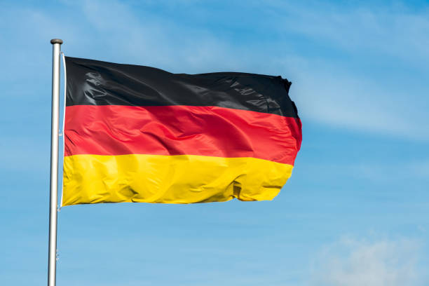 istock German flag waggling in the wind with sky in background 910944714