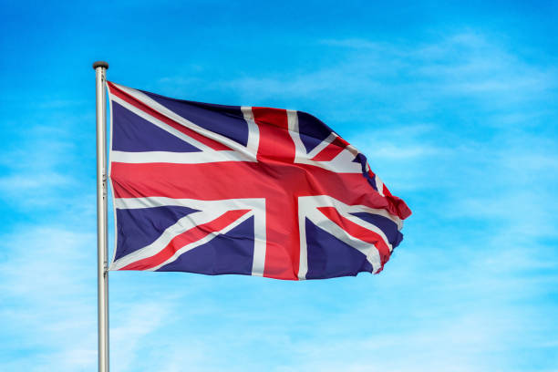 istock British union jack flag waggling in the wind with sky 910955204