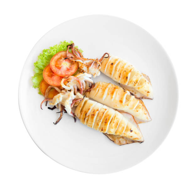 istock Grilled squid with a leaf of lettuce and tomato on a white plate 910955424