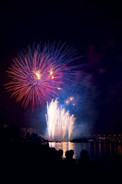 istock Colorful fireworks on night sky over water 910955882