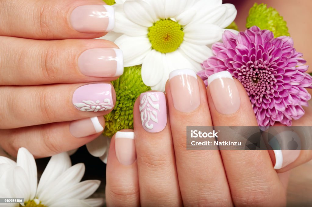 Hands with french manicured nails and flowers Hands with french manicured nails and a bouquet of flowers Fingernail Stock Photo