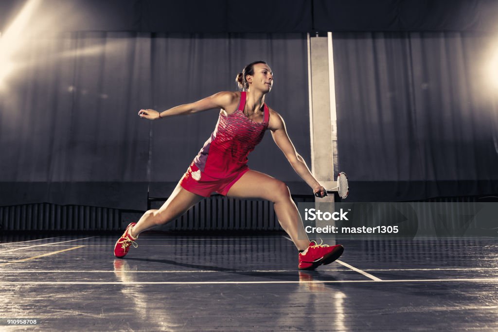 Młoda kobieta gra w badmintona na siłowni - Zbiór zdjęć royalty-free (Badminton - sport)
