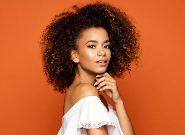 schöne afrikanische amerikanische weibliche modell - smiling single object photography orange stock-fotos und bilder