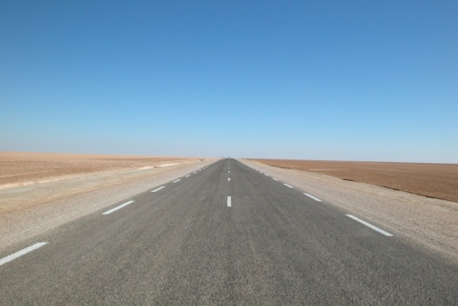 DSLR picture of a desert road in chott el jerid, Tunisia. The land is dry and flat and there is nothing around, no mountains, no vegetation, no buildings, nobody. 