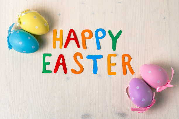 istock Happy Easter: Colourful Text and Polka Dot Easter Eggs on a Wooden Background 910967926