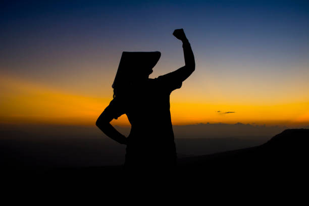 istock Silhouette Young Woman Gesturing While Standing On Mountain Against Sky During Sunset 910968818