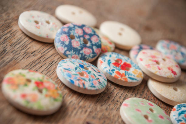 istock wooden sewing buttons with flowers pattern on wooden background 910968854