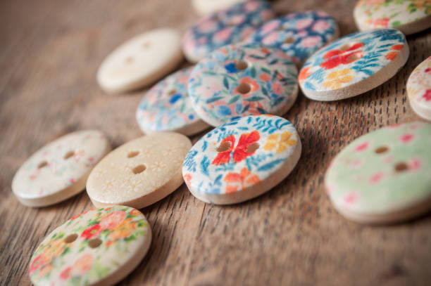 istock wooden sewing buttons with flowers pattern on wooden background 910968856