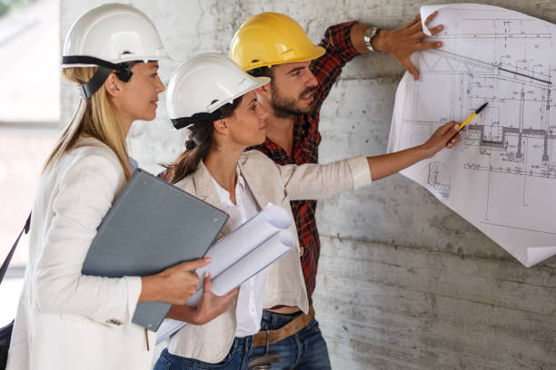 istock Team of inspectors and architects discuss about blueprints 910975362