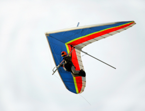 A paraglider in the blue sky. The sportsman flying on a paraglider.