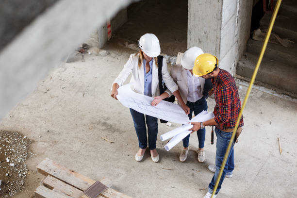 istock Female inspector and architect discuss with head engineer about project. 910983426