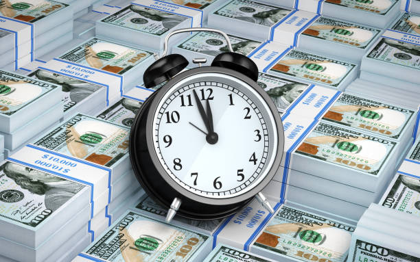 istock $100 Banknote and Alarm clock 910987288