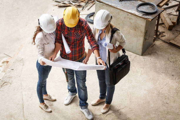 istock Female inspector and architect discuss with head engineer about project. 910987846