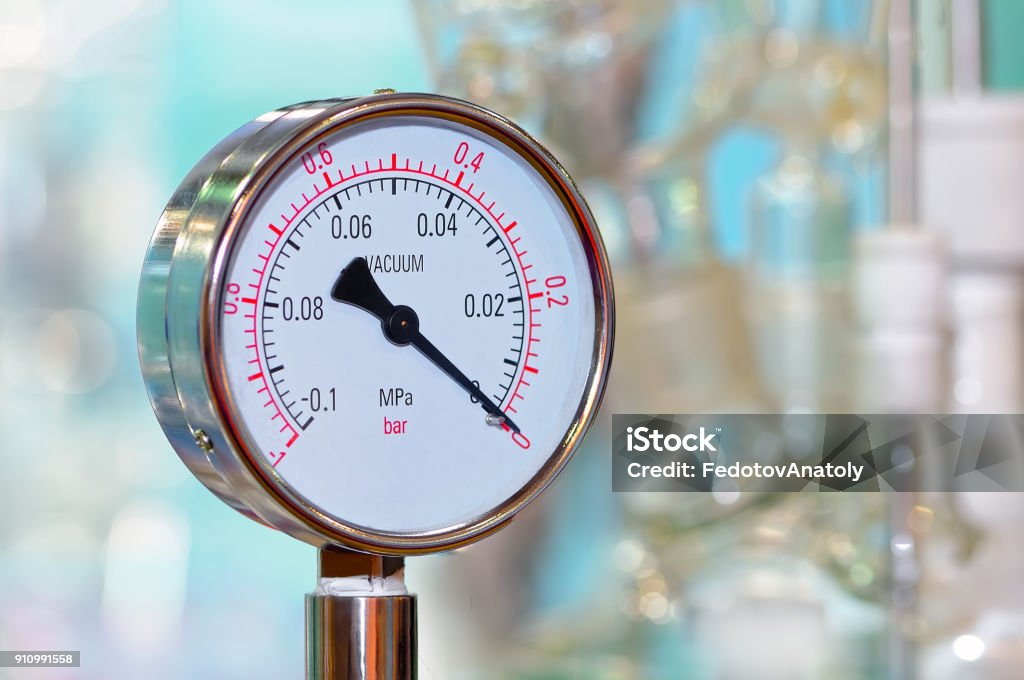 Pressure gauge on a blurry industrial background. Pressure gauge on a blurry industrial background. Black and white toned image. Accuracy Stock Photo