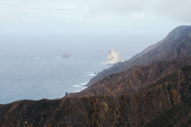 istock Volcanic landscape with cliffs on coastline in haze 910994652