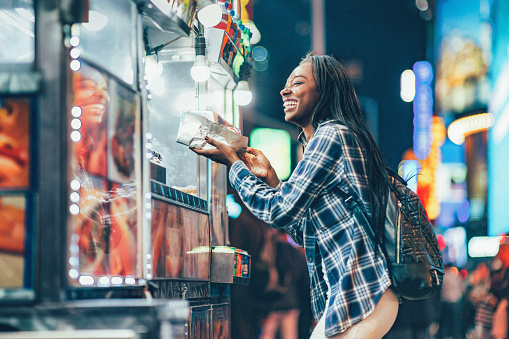 Africa American Woman at a Hot Dog Stand in Times Square, New York City.