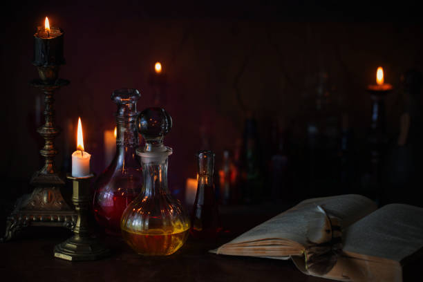 istock Magic potion, ancient books and candles on dark background 911000270