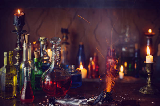 istock Magic potion, ancient books and candles on dark background 911000280