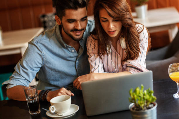 istock Young couple sitting at the internet cafe and relaxing on coffee break. 911000730