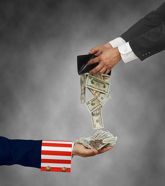 Hands giving money to a patriotic hand to show Tax Day stock photo