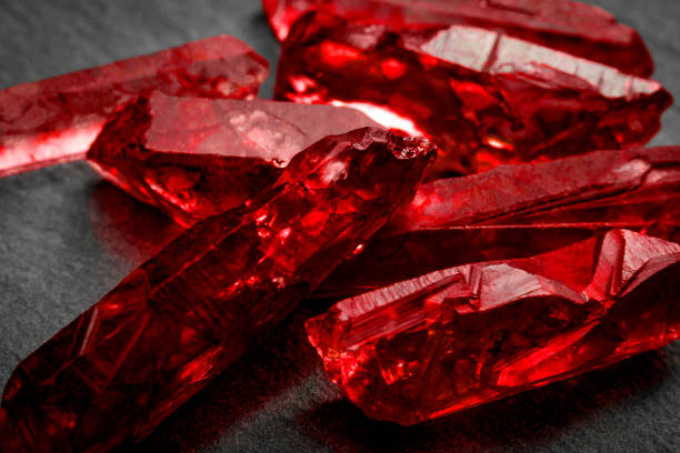nahaufnahme von ein paar rote raue ungeschnitten rubinrote kristalle - rubinrot stock-fotos und bilder