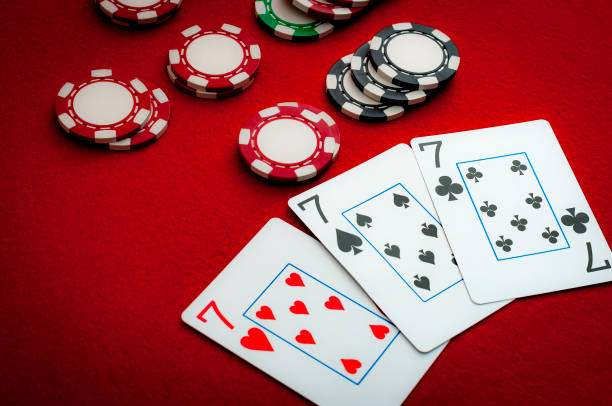 three of a kind (trip sevens) on poker card table