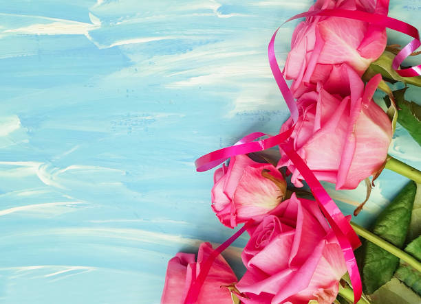istock pink rose on a blue wooden background 911007142