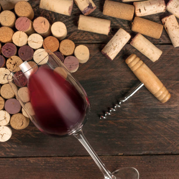 istock Glass of red wine and corks on dark background 911007362
