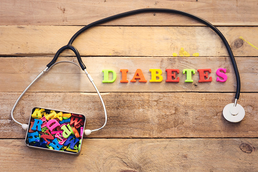 concept diabetes, heart stethoscope and colorful letters in metal box
