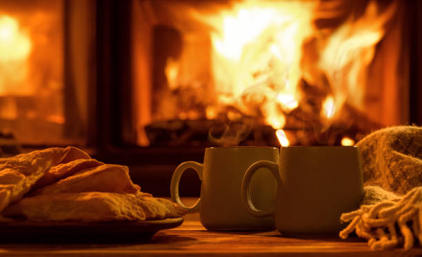 Steam from a cups with a hot cocoa on the fireplace background. stock photo