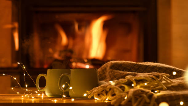 istock Steam from a cups with a hot cocoa on the fireplace background. 911008306
