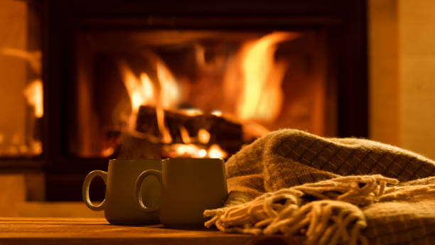 el vapor de tazas con un chocolate caliente en el fondo de la chimenea. - té bebida caliente fotografías e imágenes de stock