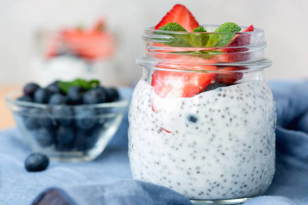 pudín de chía en frasco con fresas, arándanos y menta - yogurt yogurt container strawberry spoon fotografías e imágenes de stock