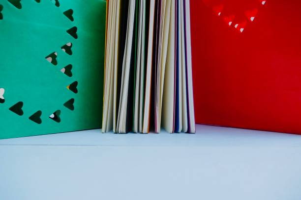 Colorful notebooks and abstract hearts in background