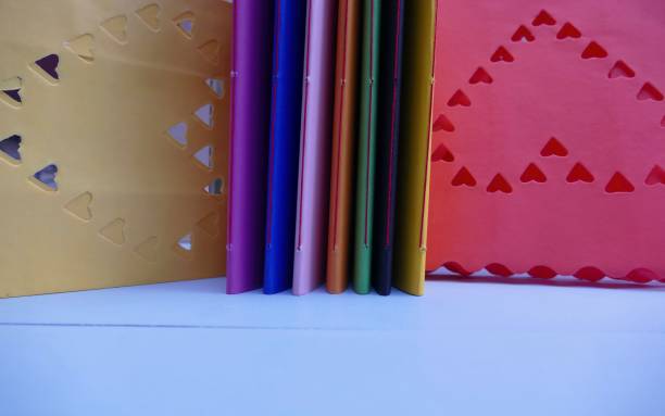 Colorful notebooks and abstract hearts in background