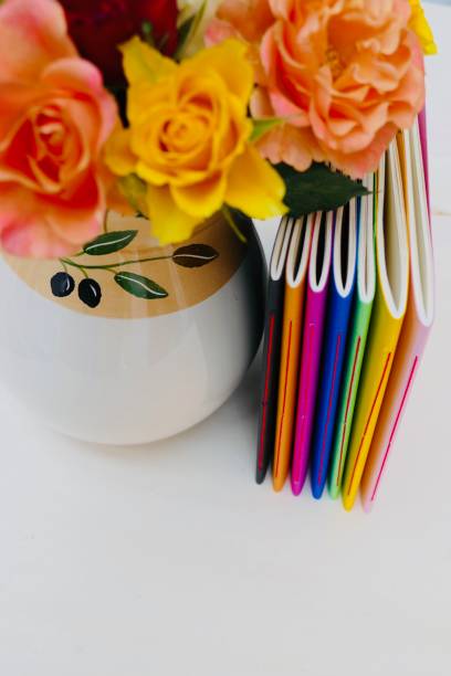 Colorful notebooks and colorful roses left of it