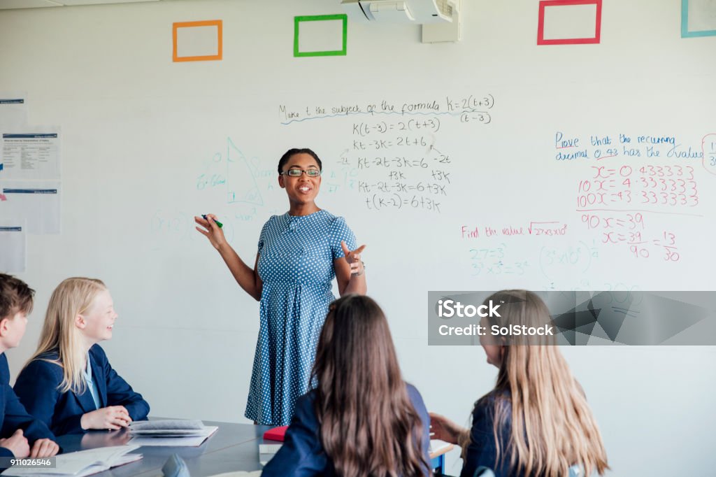 Teaching a Class Female teacher discussing STEM: Mathematics during class. Teacher Stock Photo