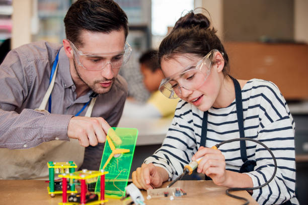 Supporting a Student Male teacher helping student with construction in STEM lesson. Internships for High School stock pictures, royalty-free photos & images