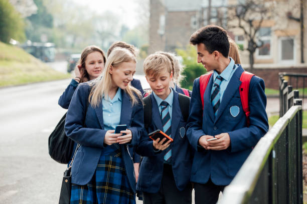 Home Time Group of teenage students walking home from school together. school uniform stock pictures, royalty-free photos & images