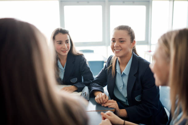 Talking During Class Teenager female students talking during a lesson. female high school student stock pictures, royalty-free photos & images