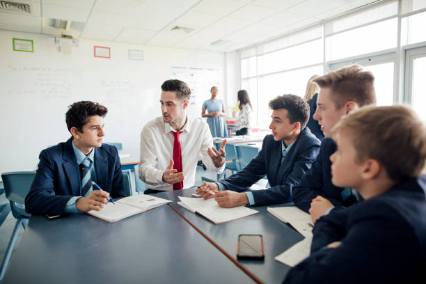 Classroom Discussion Young male student teacher talking to struggling students. nontraditional student photos stock pictures, royalty-free photos & images