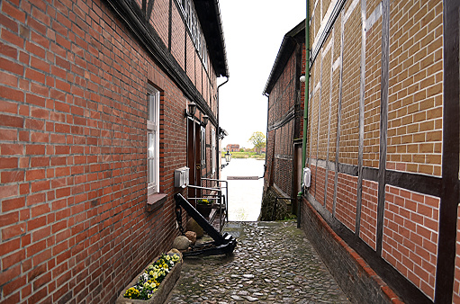 Historical cobblestone alley with half-timbered houses at a rainy day