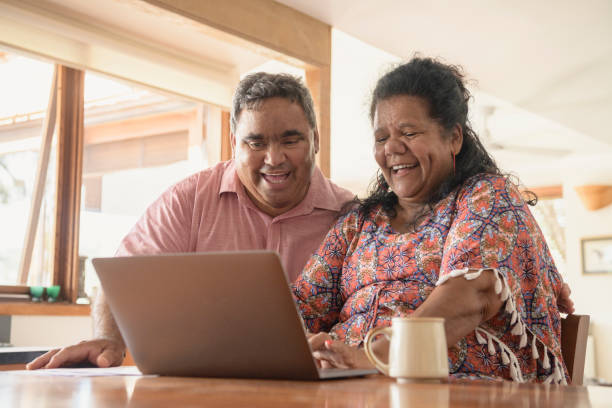 istock Mature Aboriginal couple looking at laptop and laughing 911034648
