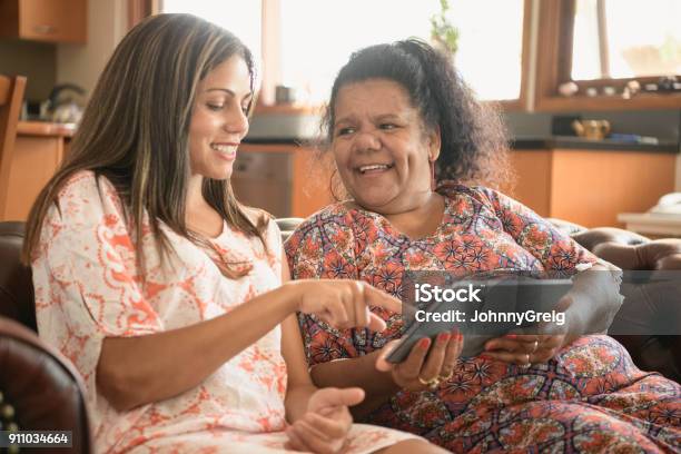 Two Women Using Digital Tablet Smiling And Laughing Stock Photo - Download Image Now