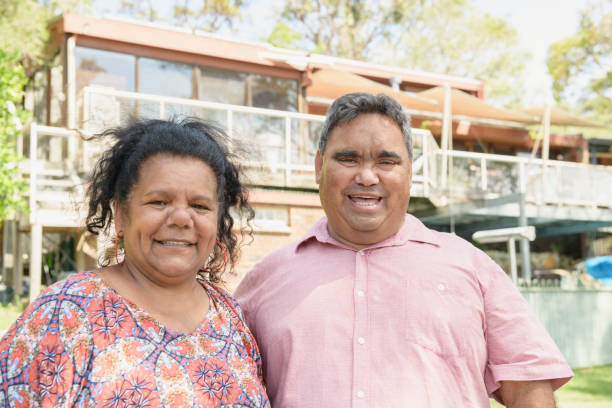 istock Aboriginal couple smiling toward camera outside house 911034666