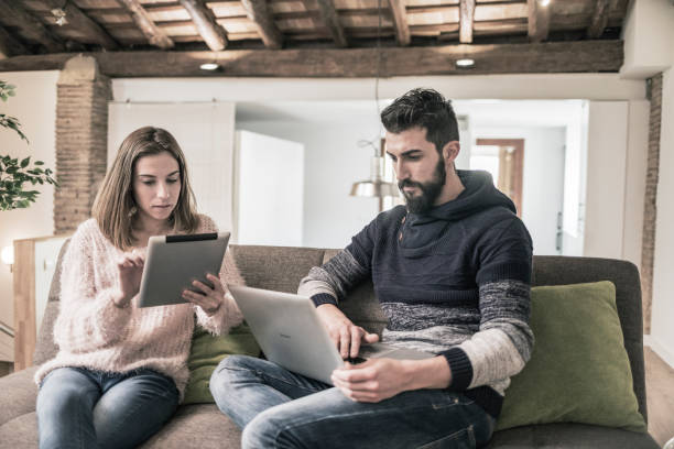 istock Couple using laptop computer and tablet at home 911038844
