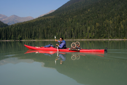 Glacial Lake Canoeing. Caucasian Sportsman in the Kayak on the Turquoise Water. Norwegian Expedition.