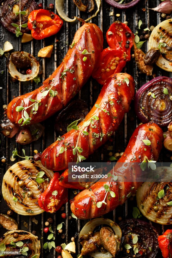 Grilled sausages and vegetables with addition spices and fresh herbs Grilled sausages and vegetables with addition spices and fresh herbs, top view Sausage Stock Photo